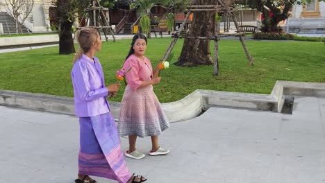 women in traditional thai clothing at a temple