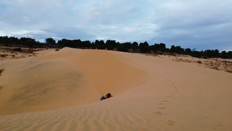 female walking up the red sand dunes in vietnam