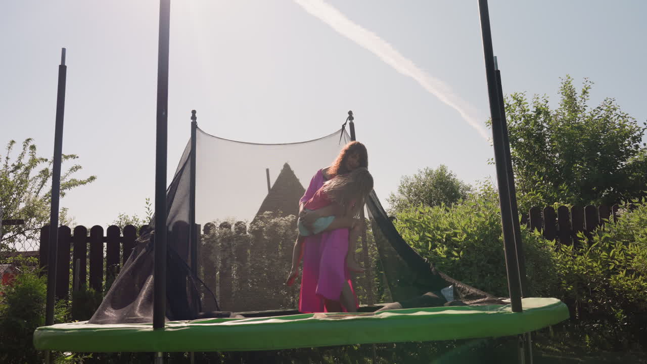 Enthusiastic Young Girls In Colorful Outfits Enjoy Outdoor Trampoline Fun, Two Lively Girls Dressed Inventively Engage Energetically In Outdoor Bouncing Activities Under Bright Sunlight