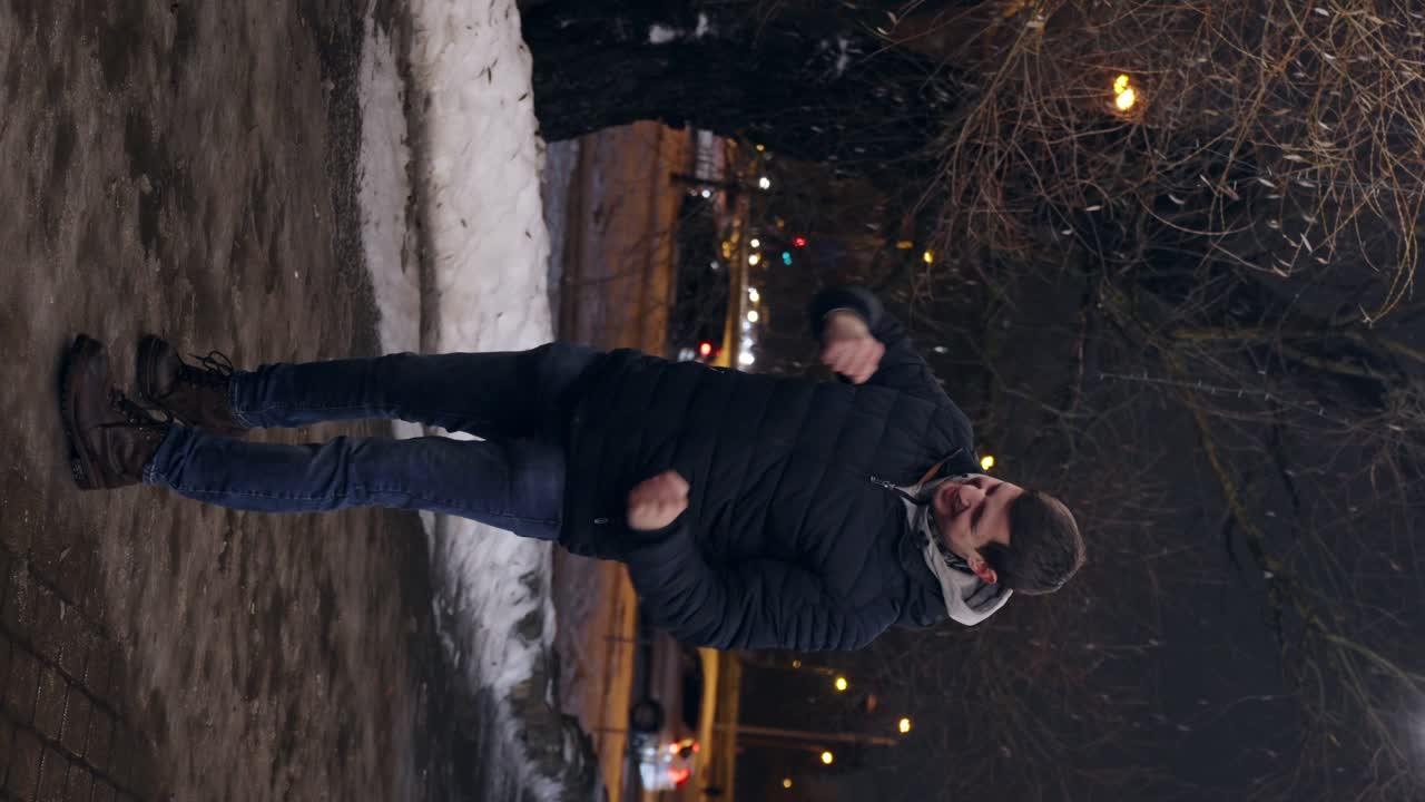 Glad ung mann hopper opp og feirer seier med håndbevegelser, vertikal video