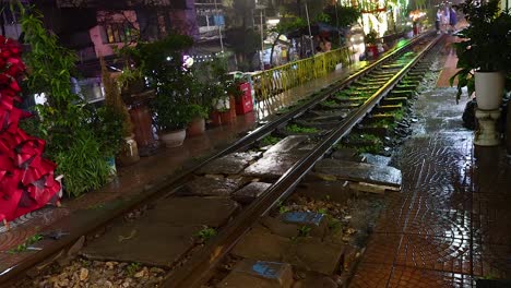 wet railway tracks with surrounding decorations at night