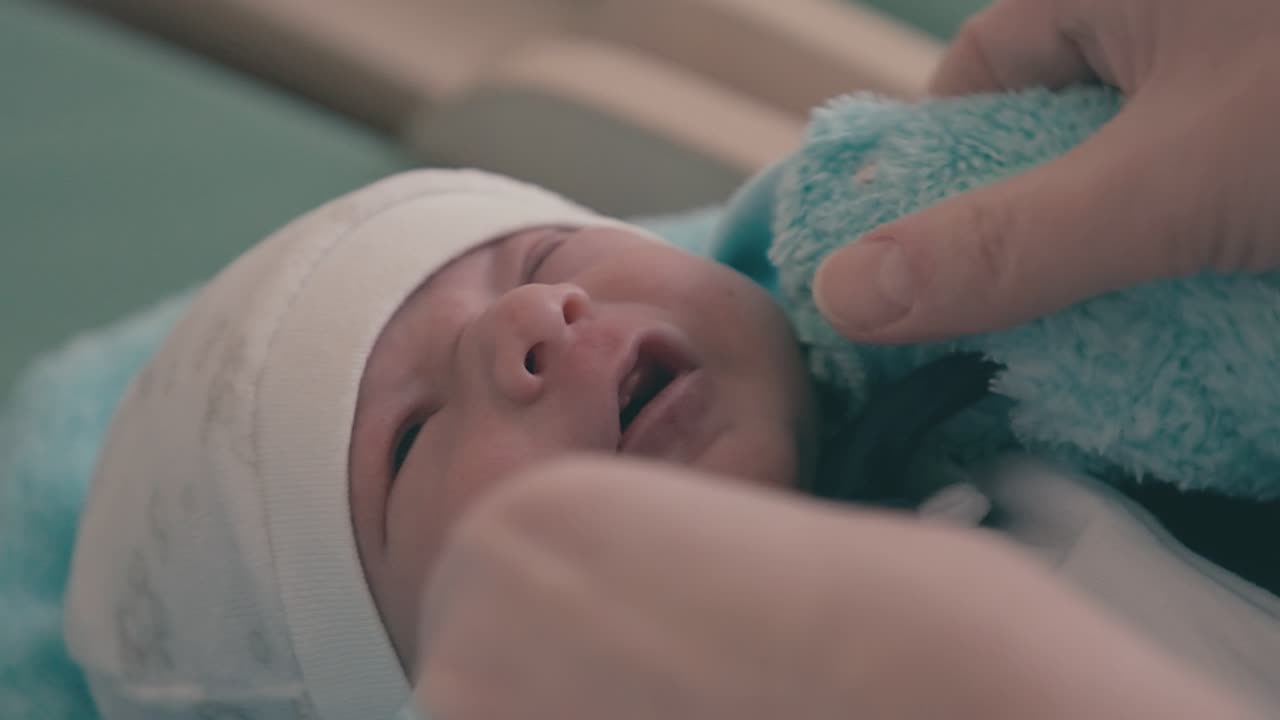 la madre attenta indossa la tuta blu soffice del neonato