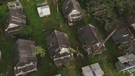 aerial sideways dolly of broken bungalow rooftops at a abandoned and derelict beach bungalow tourist resort in koh chang thailand due to the effect of covid on global travel and tourism