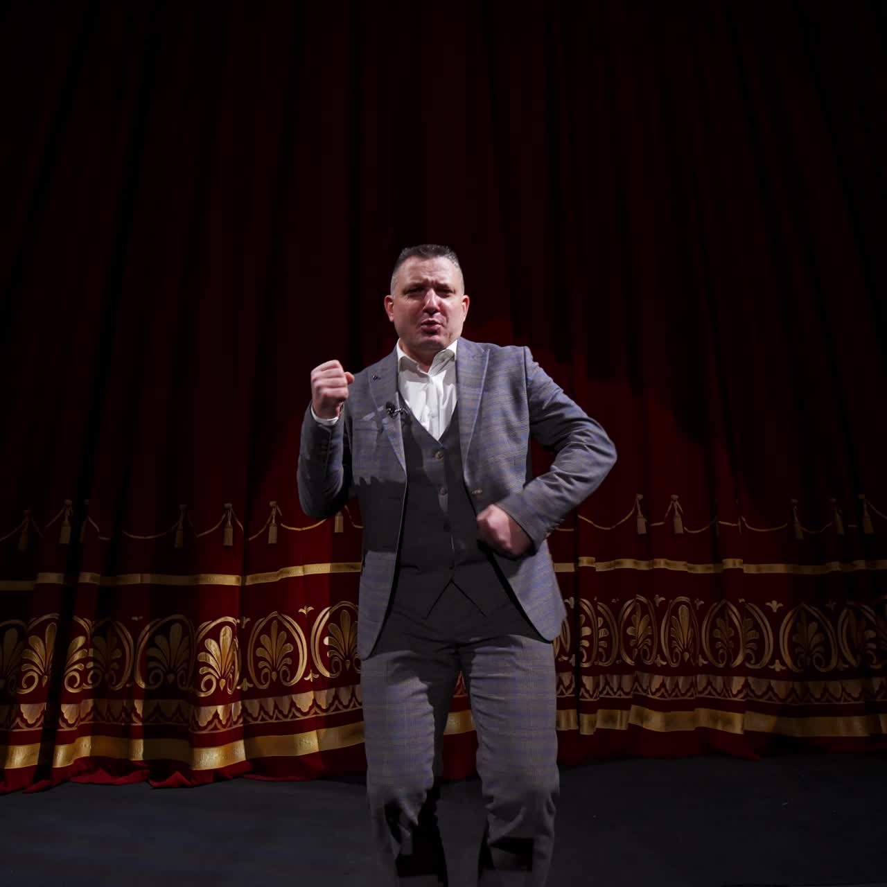 Showman dances on a stage. Senior male entertainer, presenter or actor on stage. Selective focus on a male in suit