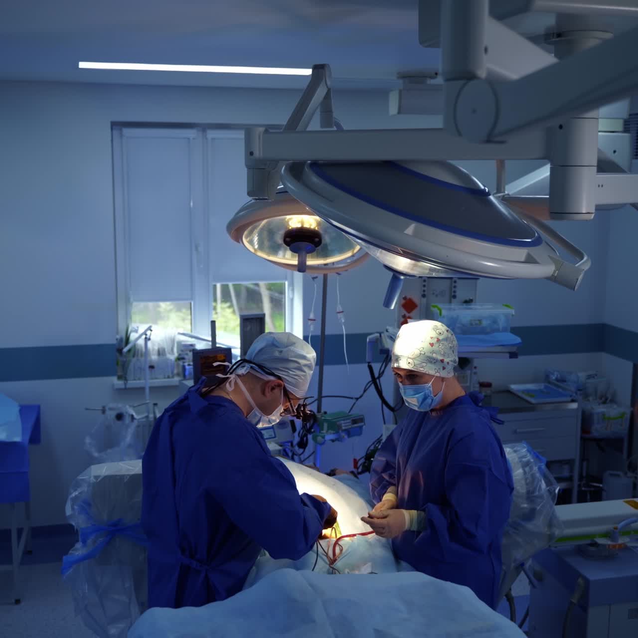Neurosurgical procedure in clinic. Professional doctor and a nurse conduct a surgery to a patient on a surgical table. Top view