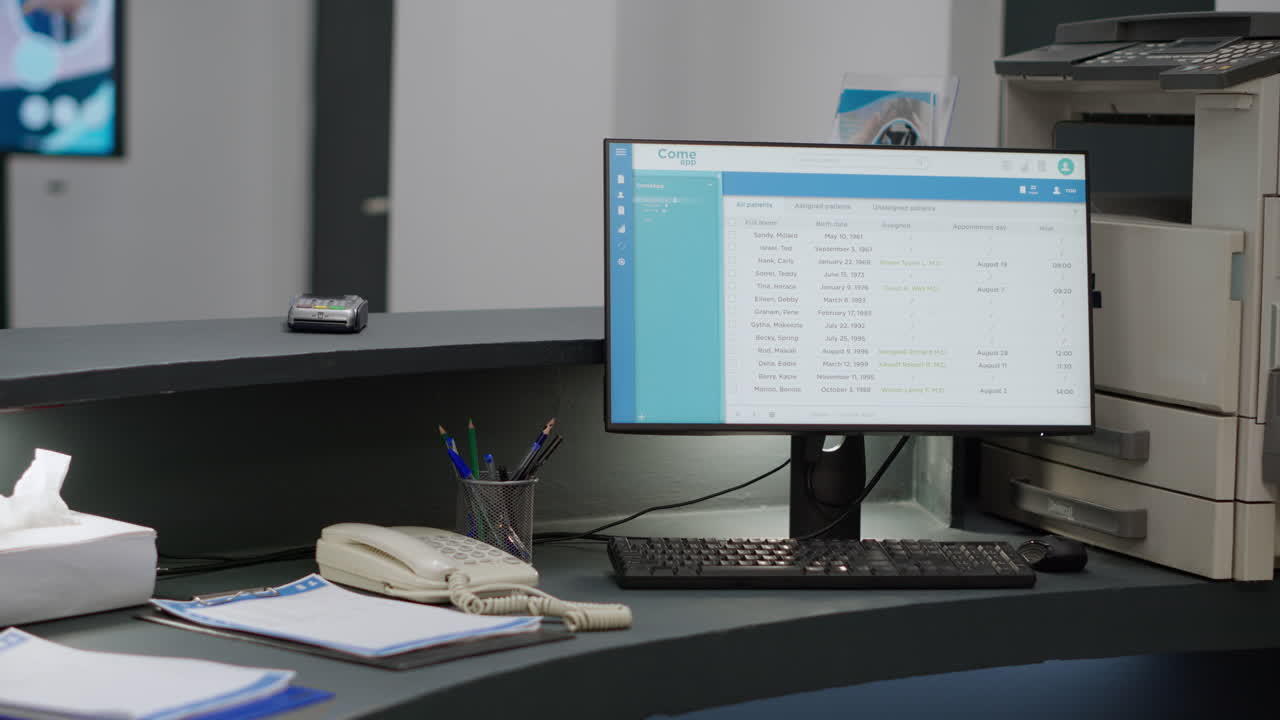 Office desk with a computer showing an appointment schedule