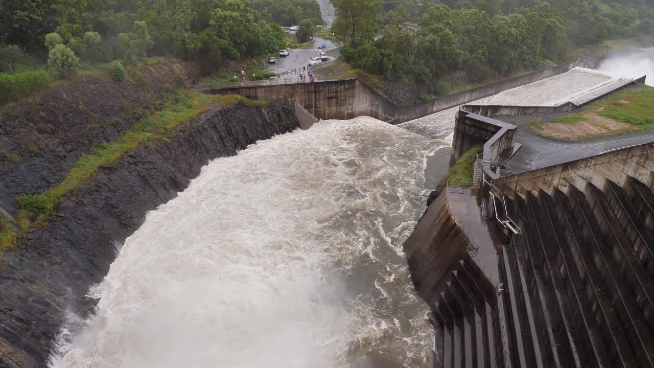 Handheld shot of Hinze Dam water outflows under heavy rain during La Ni&ntilde;a, Gold Coast Hinterland, Queensland, Australia