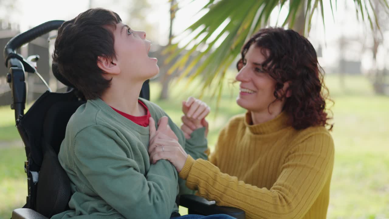 Child in wheelchair with caregiver outdoors