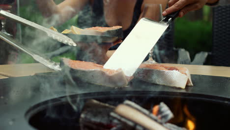 fellows using kitchen tools outside. unknown men cooking fish on mangal outdoors