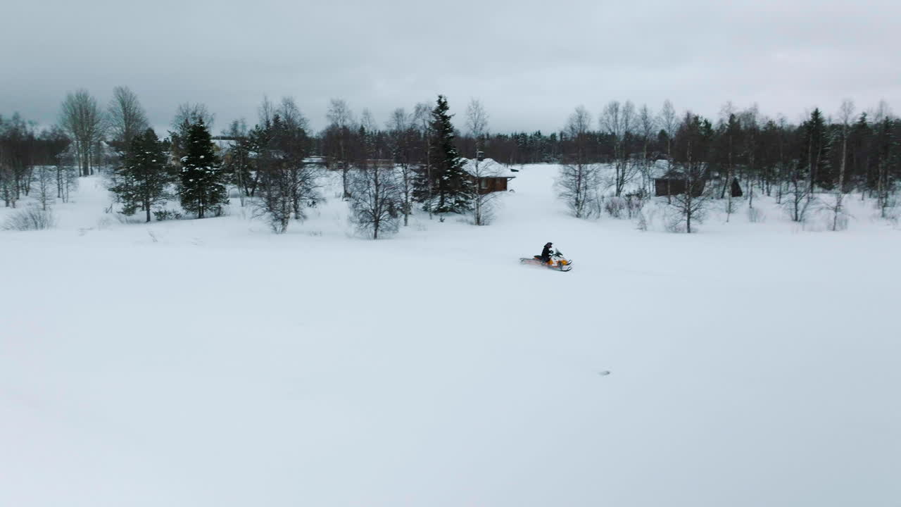 Mann kjører snøscooter gjennom den tykke snøen om vinteren i Muonio, Finland nær Lappland