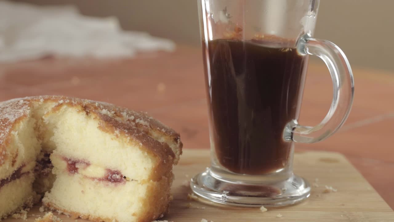 Coffee and slice of Victoria sponge cake with hot drink medium shot