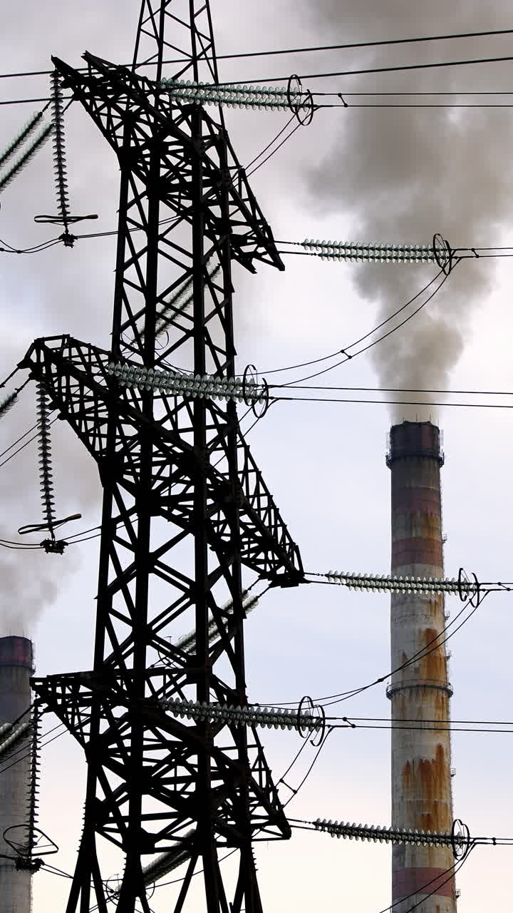 Ecological problems. Transmission lines near the industry. Thick smoke from pipes filling the air. Chemical fumes pollute the atmosphere. Vertical video