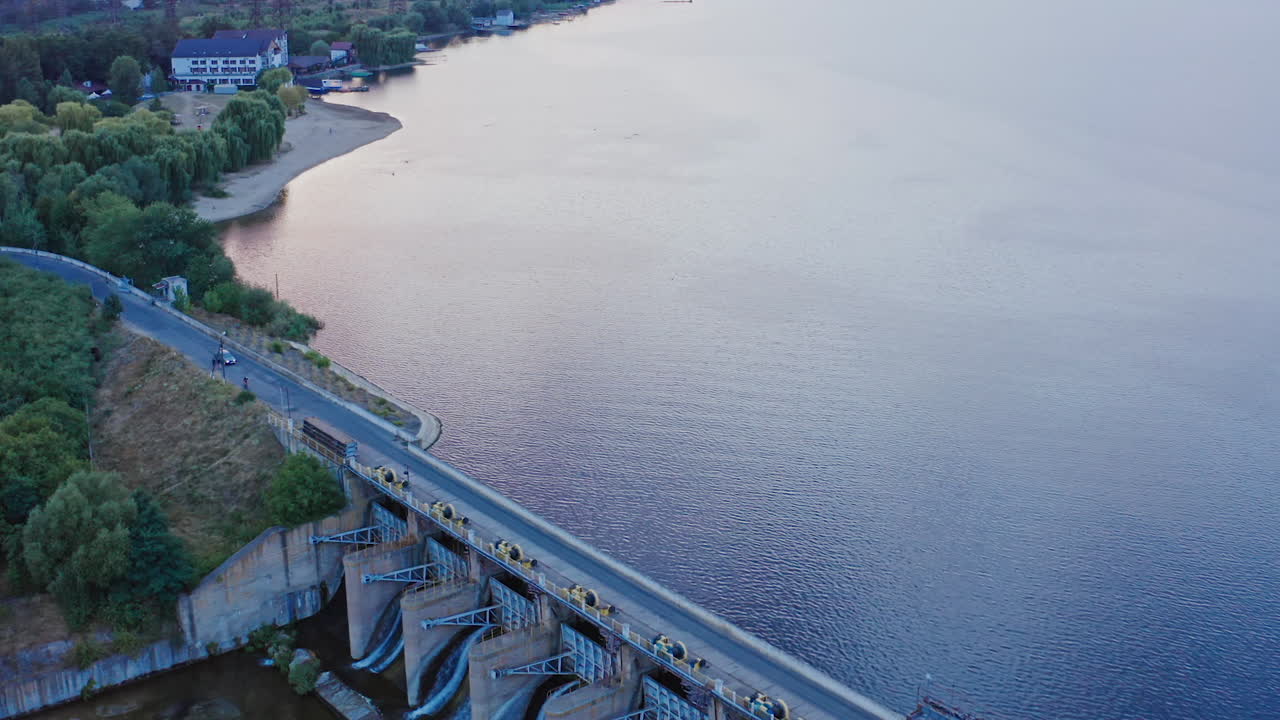 Panoramic view of a river. Flight over the beautiful river in the countryside. Industrial plant near the lake at sunset. Aerial view.