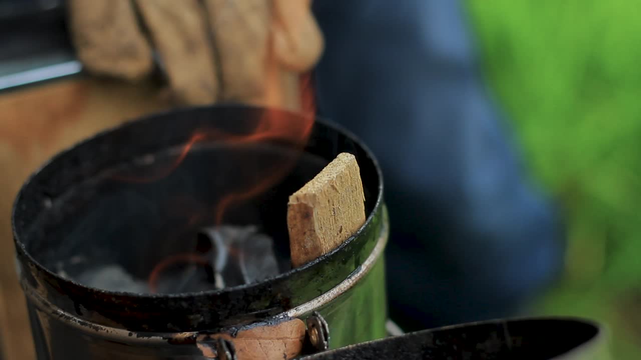 Beekeper lighting a bee smoker