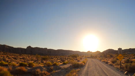 Driving-on-a-dirt-road-towards-the-famous-RedRock-Canyon-State-park-sandstone-cliffs