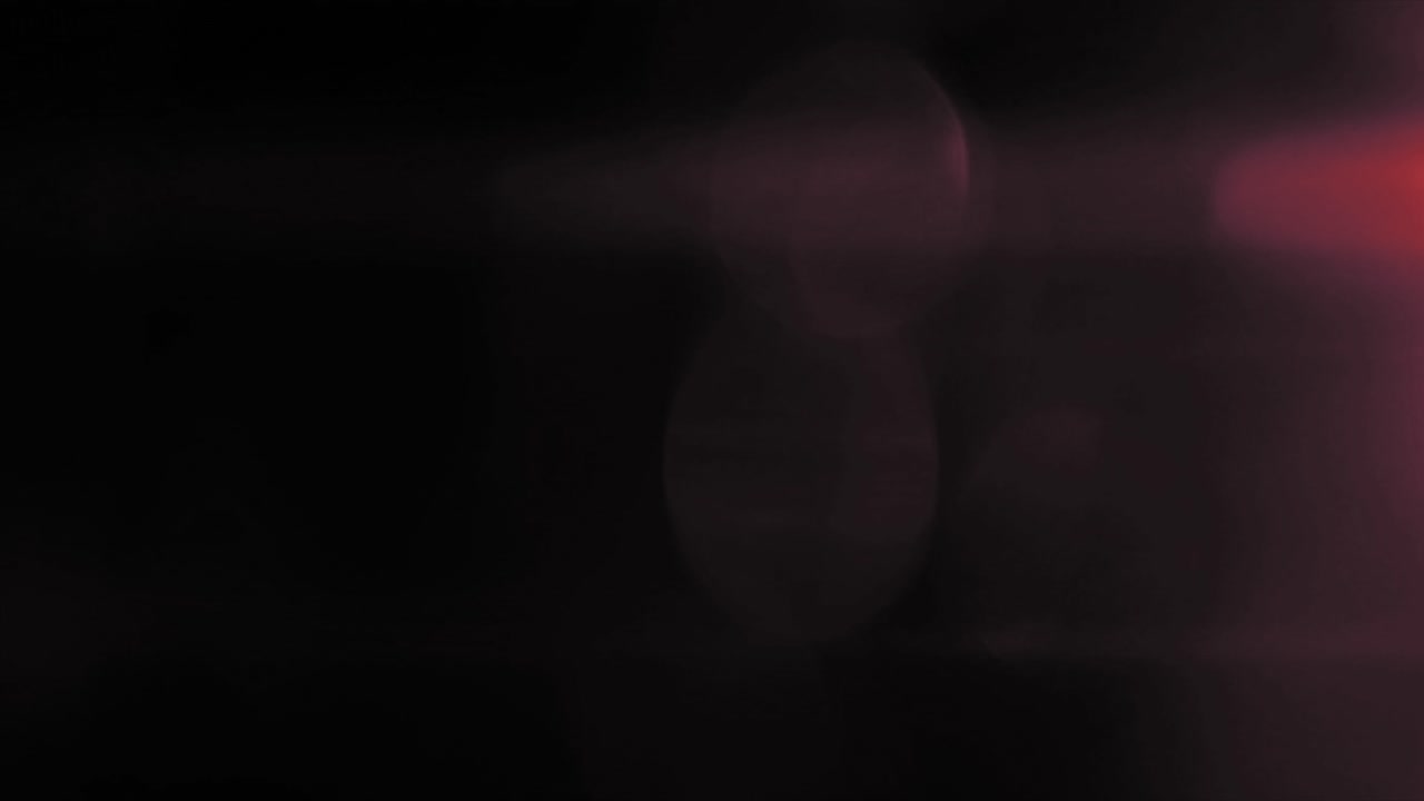 Svagt rødt lysindfald fra højre side med bløde, slørede bokeh-elementer. Brug det som overlay til drømmende, romantiske eller nostalgiske videoprojekter.