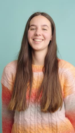 young woman smiling in various expressions against blue background