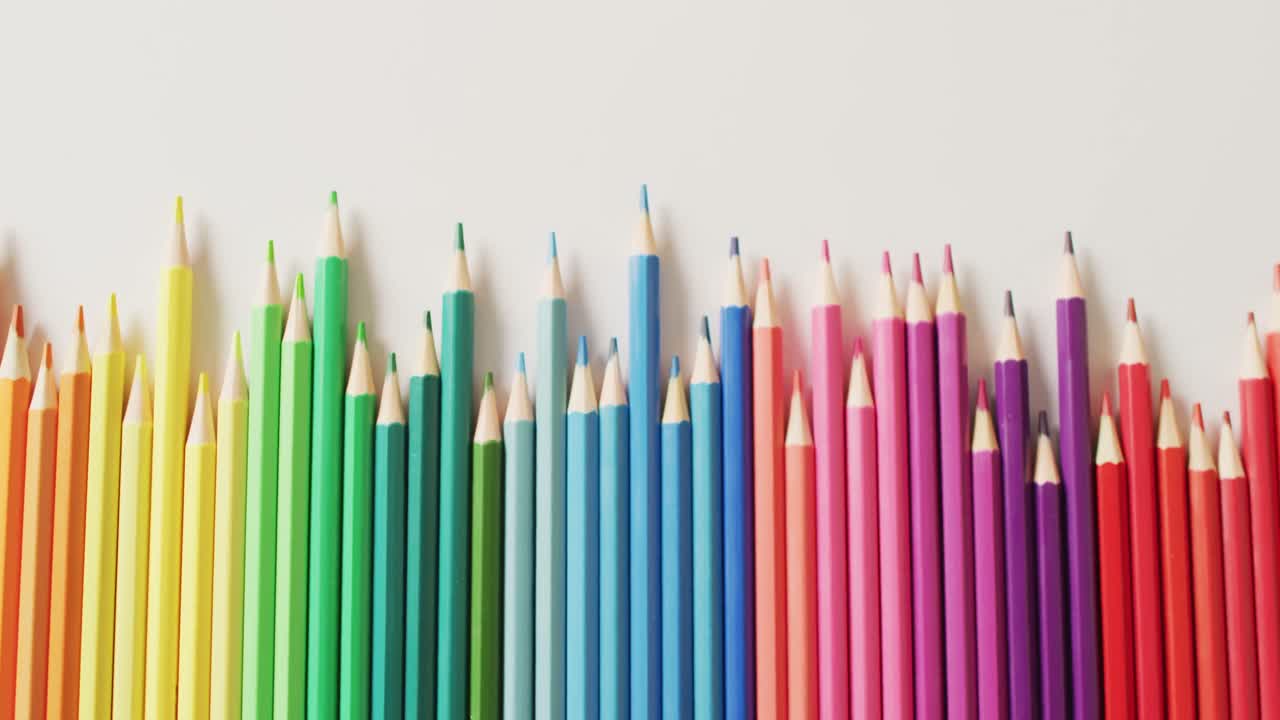 video de composición con lápices de colores en superficie rosa con espacio para copiar
