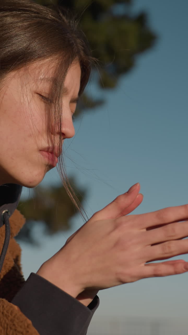 눈물을 흘리는 불행한 여자가 혼자 앉아서 깊은 생각의 몸짓으로 손을 부드럽게 마사지하고, 갈색 코트를 입고, 머리가 약간 구부려 상하며, 우울한 분위기를 반영하고 있다.