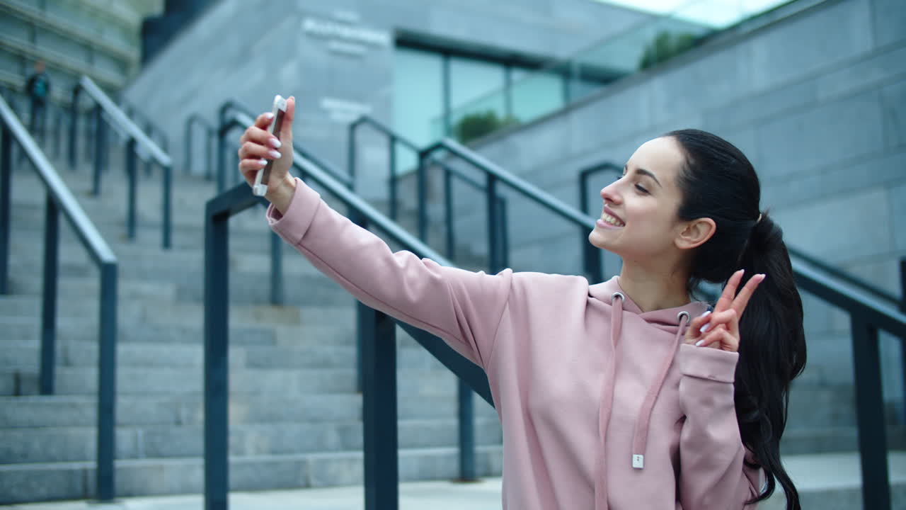mujer sonriente posando para una foto selfie al aire libre