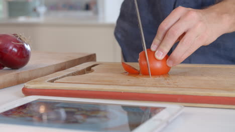 hombre sigue la receta en la tableta digital en la cocina filmado en r3d