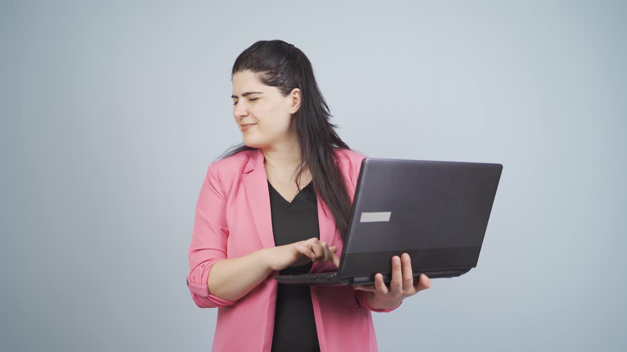 mujer de negocios mirando la computadora portátil con expresión asustada.