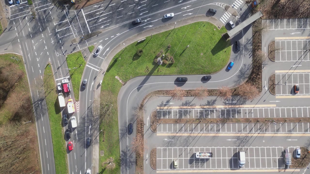 Modern city parking lot alongside urban road junction, Dortmund, Aerial view