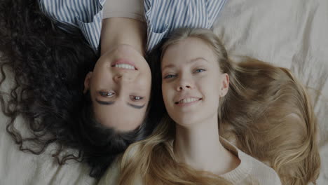 two happy women relaxing together on a bed