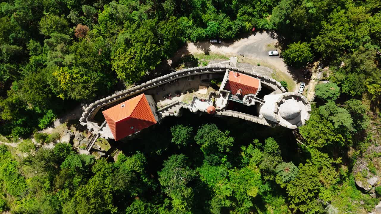 Aerial top down descend over historic Kokorin castle near green forest, Czechia