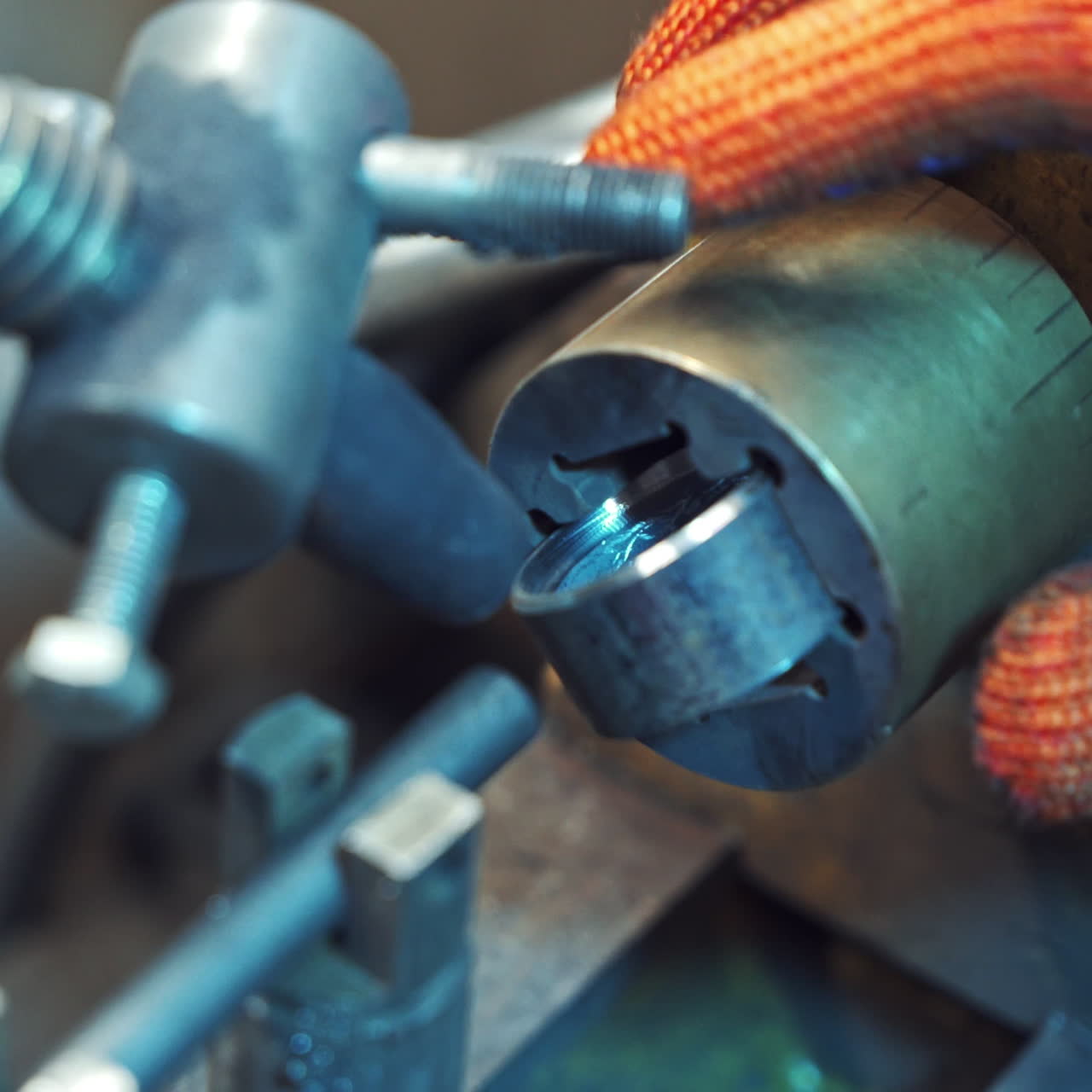 Professional machinist puts metal instruments to the machine. Man's hands operating lathe grinding machine metalworking industry concept. Close-up