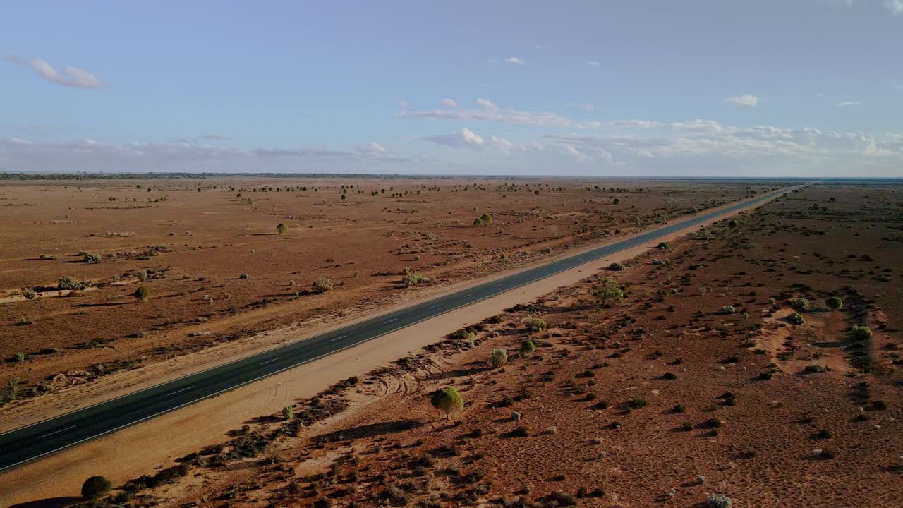 vista aérea por encima de 90 millas de carretera recta, australia en un sol, desierto del interior - órbita, disparo de dron