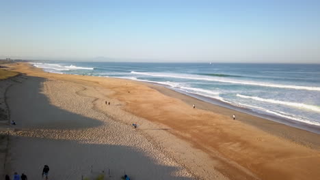 Cinematic-aerial-drone-stunning-coastline-morning-surf-huge-glassy-waves-crashing-swell-beautiful-Hossegor-Seignosse-France-Biarritz-Basque-Country-blue-water-golden-sand-beach-forward-movement