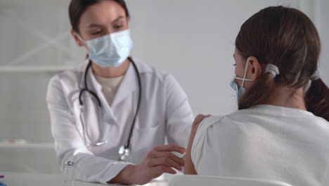 una doctora administrando una vacuna contra la covid-19 a una niña. una enfermera dando una inyección para el coronavirus.