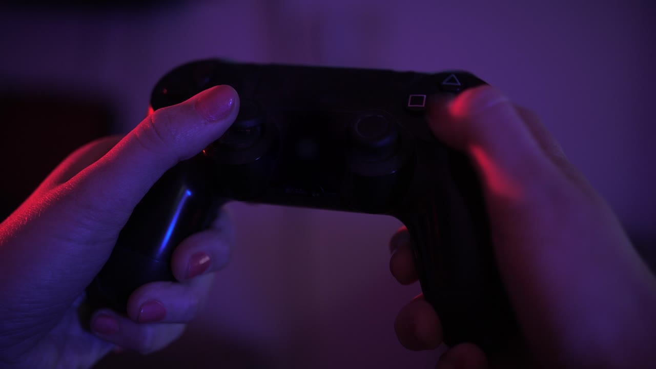 Close-Up of Hands Playing Video Game with Neon Lights