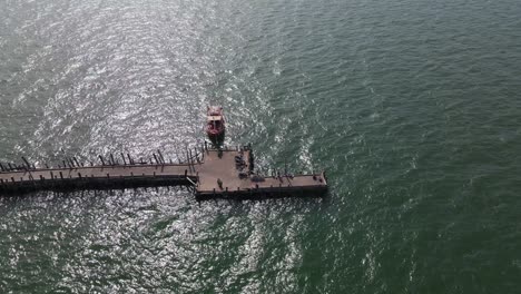 aerial steady footage of this pattaya fishing dock with a fishing boat docked from a high altitude, pattaya, thailand