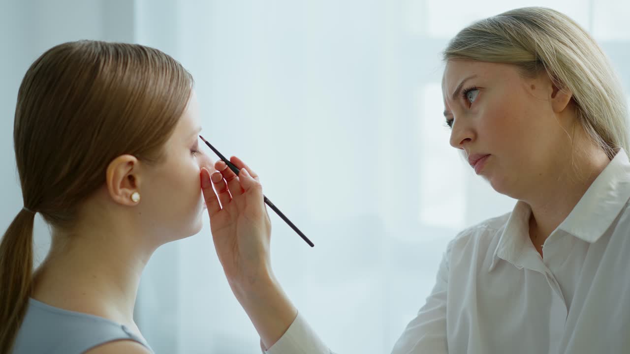 Makeup Artist Applying Makeup to Client