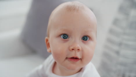 portrait-happy-baby-with-beautiful-blue-eyes-looking-curious-toddler-smiling-enjoying-life-healthy-little-infant-at-home-4k