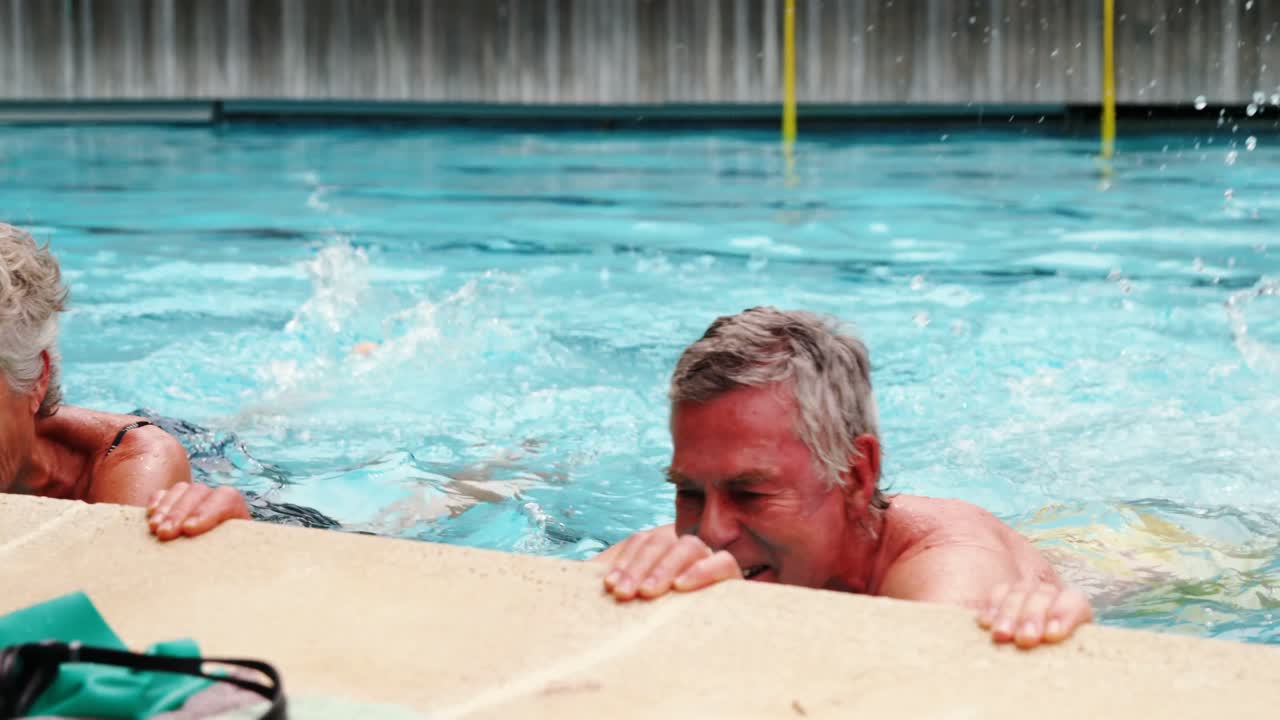 ancianos nadando en la piscina con tubos inflables