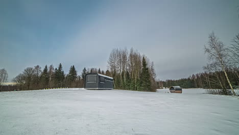 Static-video-of-small-wooden-houses-covered-in-snow-all-around-from-morning-to-evening-in-timelapse