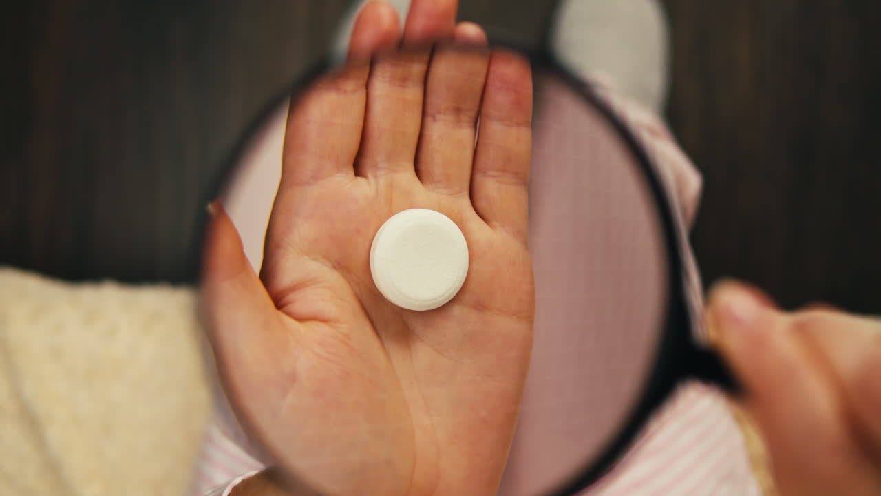 una píldora blanca siendo examinada con una lupa