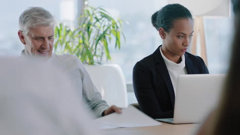 hermosa mujer de negocios en una reunión en la sala de juntas usando una computadora portátil trabajando en un proyecto de la compañía con colegas sentados en la mesa planificando la estrategia de éxito en la oficina 4k