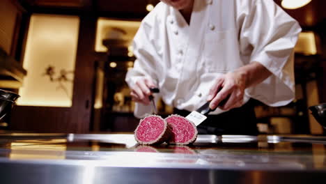 chef preparing meat on a teppanyaki grill in a restaurant kitchen