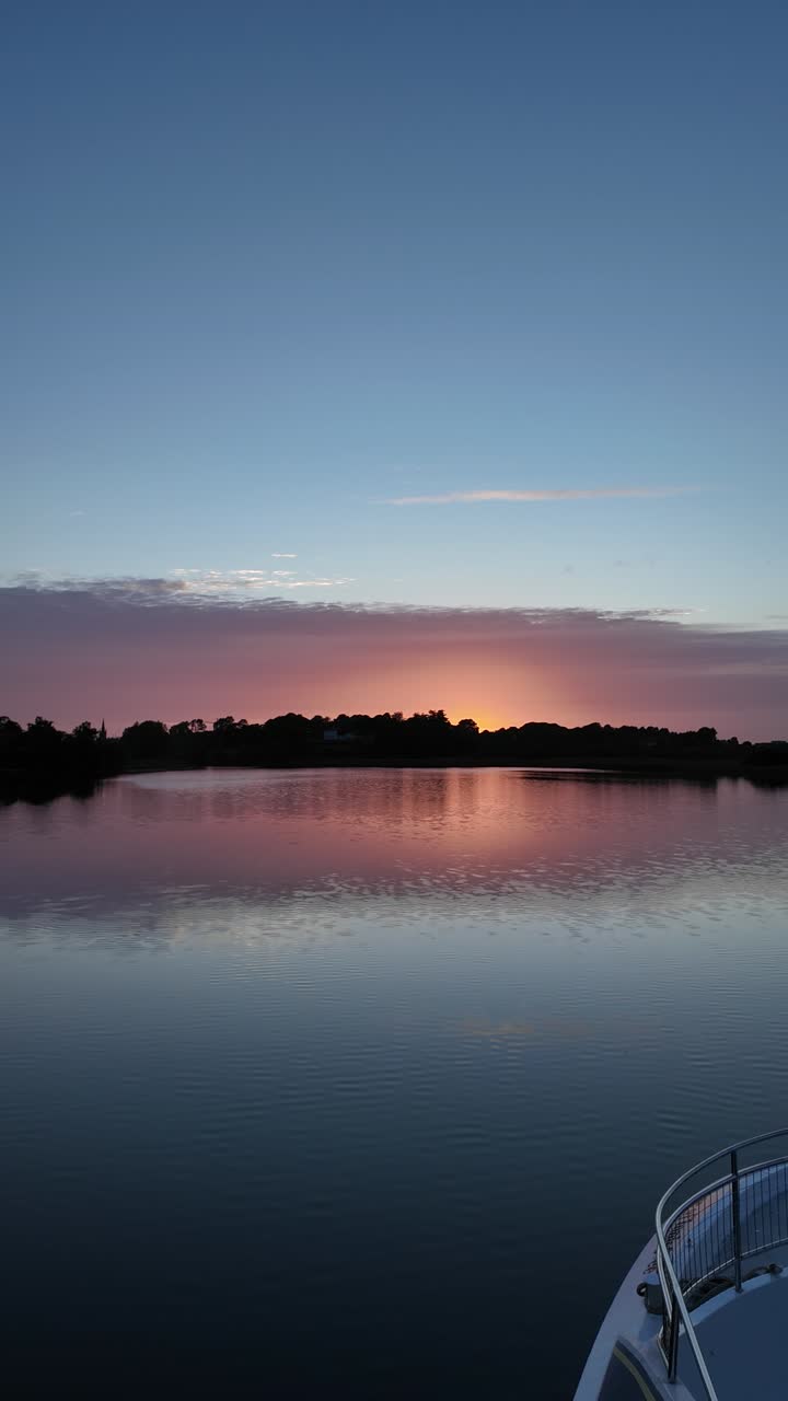 Serene River Sunset with Colorful Sky and Water Reflection