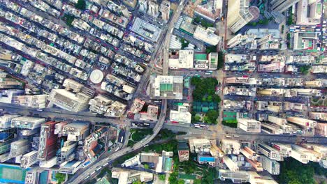 traffic passing through a car park building in downtown hong kong, with city mega buildings, aerial view