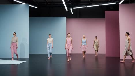 a fashion showcase: models displaying chic and elegant styles on a minimalist stage of soft pastel colors in a striking visual presentation