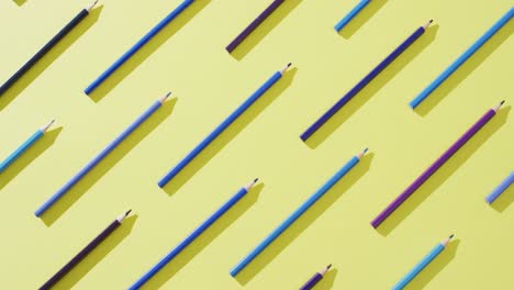 video of multi-colored crayons in a row on a yellow background