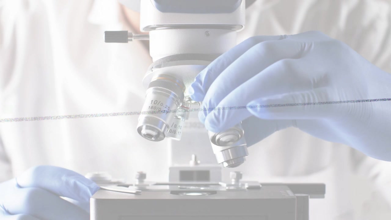Male lab researcher placing slide then rotating microscope turret, selecting objectives for imaging