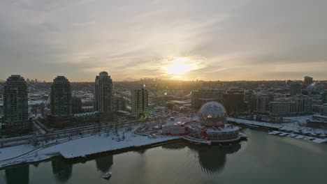 vancouver canda covered in winter snow - science world astc building downtown area - drone aerial sunset shot