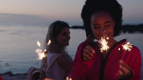 young blonde woman taking photo video of friends holding sparklers celebrating new years eve using smartphone enjoying beach party at sunset