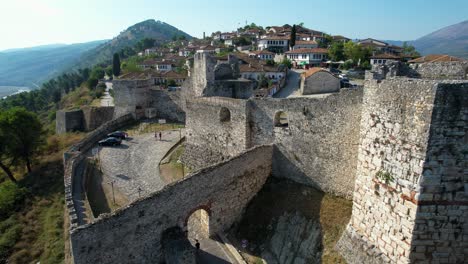 entrance gate to berat castle's historic fortress, ancient stone walls and white houses inside, tourism destination in albania